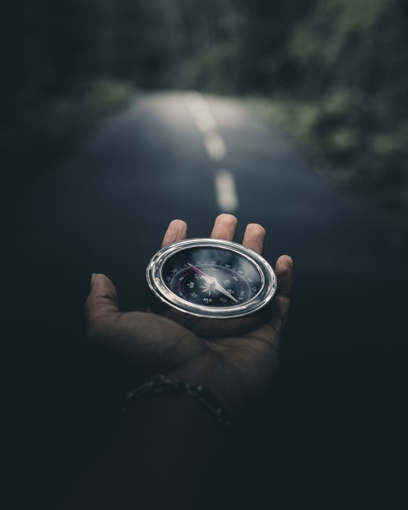 A hand holding a compass symbolizes finding the right path.